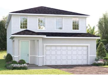 Charming two-story home with a two-car garage, complemented by lush landscaping at 6501 Domizio Dr, Winter Haven, FL 33884