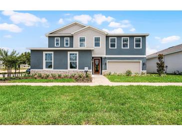 Charming two-story home with a manicured lawn, stone accents, and a welcoming front porch in a desirable neighborhood at 823 Emerald Grove Dr, Apopka, FL 32703