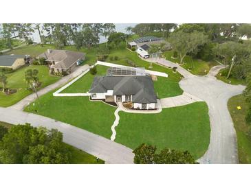 Expansive lakefront property features lush lawn, fenced yard, and screened lanai, offering privacy and serene outdoor living at 1148 Rosetta Dr, Deltona, FL 32725