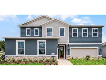 Two-story home boasts a combination of blue siding and decorative shingles at 855 Emerald Grove Dr, Apopka, FL 32703