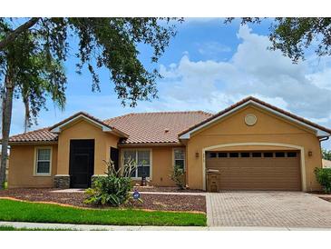 Attractive home showcasing its tile roof, well-maintained landscaping, and two-car garage with paver driveway at 3612 Northwoods Dr, Kissimmee, FL 34746