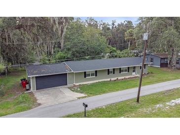 Ranch-style home featuring an attached garage, new roof, and manicured front lawn at 3207 Cr 419, Lake Panasoffkee, FL 33538