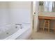 Bathroom featuring a tub, sink, and vanity area with a stool at 255 Royal Palm Dr, Davenport, FL 33837