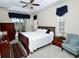 Spacious bedroom with tray ceiling, ceiling fan, dark wood furniture and access to lanai at 255 Royal Palm Dr, Davenport, FL 33837