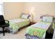 Bright bedroom featuring two twin beds with colorful floral-patterned bedding and a comfortable chair at 255 Royal Palm Dr, Davenport, FL 33837