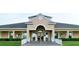 Elegant clubhouse exterior with manicured landscaping, offering a welcoming entrance with ornate glass doors and attractive architectural details at 255 Royal Palm Dr, Davenport, FL 33837