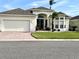 Charming single-story home with a two-car garage, manicured lawn, and beautiful tropical landscaping at 255 Royal Palm Dr, Davenport, FL 33837
