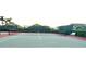 A community tennis court is ready for a match with green and red painted surface, bench seating, and netting at 255 Royal Palm Dr, Davenport, FL 33837
