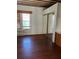 Bedroom with wood flooring, a window, and mirrored closet at 1116 W Line St, Leesburg, FL 34748