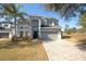 Two-story home featuring a well-manicured lawn, a paver driveway, and a two-car garage at 33953 Terragona Dr, Sorrento, FL 32776