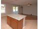 Kitchen island featuring granite countertop, wooden cabinets and an open concept view to the living room at 33953 Terragona Dr, Sorrento, FL 32776