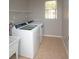 Laundry room includes a large sink, tile floor, and window at 33953 Terragona Dr, Sorrento, FL 32776