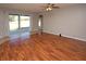 Bright living room with wood floors, ceiling fan, and sliding glass doors to the outside patio at 33953 Terragona Dr, Sorrento, FL 32776