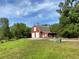 Large red barn with white trim, set against a backdrop of blue sky and lush green foliage at 850 Eden Dr, Saint Cloud, FL 34771