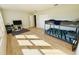 A bedroom featuring light wood floors, a bunkbed, a TV, and a light-filled window at 9123 Silver Lake Dr, Leesburg, FL 34788