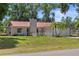 Charming single-story home featuring a well-maintained yard, a red roof, and mature landscaping at 3240 Flamingo Ln, Mulberry, FL 33860