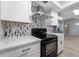 Modern kitchen featuring stainless steel appliances, white cabinets, and decorative backsplash at 3240 Flamingo Ln, Mulberry, FL 33860