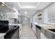 Modern kitchen with stainless steel appliances, white cabinetry, and gray backsplash at 3240 Flamingo Ln, Mulberry, FL 33860