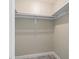 Walk-in closet featuring laminate flooring, white shelves, and a clothes rod at 3240 Flamingo Ln, Mulberry, FL 33860