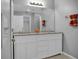 Bathroom with double vanity, granite countertop, and mirrored medicine cabinet at 518 Marion Oaks Trl, Ocala, FL 34473