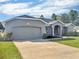 Gray house with a gray garage door and landscaped yard at 518 Marion Oaks Trl, Ocala, FL 34473