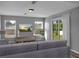 Bright living room with gray sofa, large window, and sliding glass door leading to backyard at 518 Marion Oaks Trl, Ocala, FL 34473