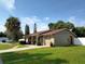 Tan house with red roof, palm tree, and driveway at 11432 Cardiff Dr, Orlando, FL 32837