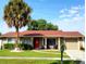 Tan house with red roof, palm tree, and landscaped lawn at 11432 Cardiff Dr, Orlando, FL 32837