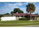 Tan house with red roof, white fence, and palm tree at 11432 Cardiff Dr, Orlando, FL 32837