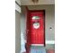 Inviting red front door with a welcome wreath, showcasing a charming entryway at 11432 Cardiff Dr, Orlando, FL 32837