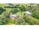 Aerial view of the property featuring the log cabin home, barn, and surrounding landscape at 4292 Sw 73Rd Trl, Bushnell, FL 33513