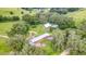 Aerial view of the log cabin home and pastures surrounded by mature trees at 4292 Sw 73Rd Trl, Bushnell, FL 33513