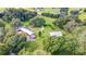 Aerial view of a log cabin home, barn, and acreage surrounded by mature shade trees at 4292 Sw 73Rd Trl, Bushnell, FL 33513