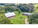 A beautiful aerial view of the log home and property, including the expansive green lawn, mature trees, and additional structures at 4292 Sw 73Rd Trl, Bushnell, FL 33513
