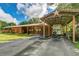 Equestrian barn featuring a covered horse trailer parking area and spacious stalls for horses at 4292 Sw 73Rd Trl, Bushnell, FL 33513