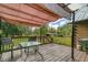 Outdoor deck featuring a shaded pergola, a table with chairs, and a beautiful view of the surrounding green area at 4292 Sw 73Rd Trl, Bushnell, FL 33513