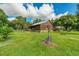 Charming exterior of log home featuring front porch, landscaped yard, and classic windmill accent in a lush green setting at 4292 Sw 73Rd Trl, Bushnell, FL 33513