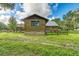 Log cabin featuring a rustic exterior with stone foundation and fenced in yard at 4292 Sw 73Rd Trl, Bushnell, FL 33513