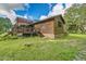 Charming log cabin exterior featuring a spacious deck and stone foundation at 4292 Sw 73Rd Trl, Bushnell, FL 33513
