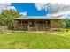 Charming log cabin home with a metal roof, inviting front porch, and well-manicured lawn at 4292 Sw 73Rd Trl, Bushnell, FL 33513