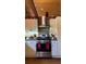 Farmhouse style kitchen boasting stainless steel appliances and light colored cabinetry under exposed wood ceiling beams at 4292 Sw 73Rd Trl, Bushnell, FL 33513