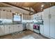 Well-lit kitchen features white cabinetry, stainless steel appliances, and a unique wood paneled ceiling with exposed beams at 4292 Sw 73Rd Trl, Bushnell, FL 33513