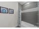 Bathroom featuring a bathtub, shower curtain and modern gray and white tiling at 17531 Placidity Ave, Clermont, FL 34714