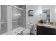 Bathroom featuring a glass shower, granite countertop, dark cabinets, and decorative lighting at 17531 Placidity Ave, Clermont, FL 34714