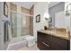 Bathroom featuring a glass shower, granite countertop, dark cabinets, and modern brown tiling at 17531 Placidity Ave, Clermont, FL 34714