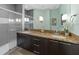 Modern bathroom with double vanity, granite countertops, and glass-enclosed shower at 17531 Placidity Ave, Clermont, FL 34714