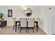 A well-lit dining room with modern furnishings, a round mirror, and tile floors at 17531 Placidity Ave, Clermont, FL 34714