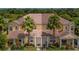 Inviting townhome featuring a well-maintained facade with palm trees and a lush green lawn at 17531 Placidity Ave, Clermont, FL 34714