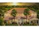 Inviting townhome featuring a well-maintained facade with palm trees and a lush green lawn at 17531 Placidity Ave, Clermont, FL 34714