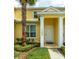 Bright yellow home exterior with white trim, featuring a front door and lush landscaping at 17531 Placidity Ave, Clermont, FL 34714